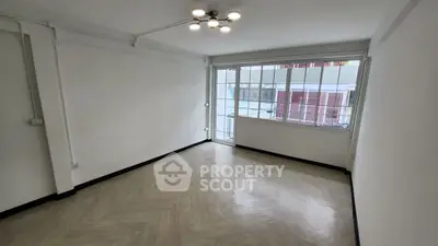Spacious empty room with large windows and modern lighting
