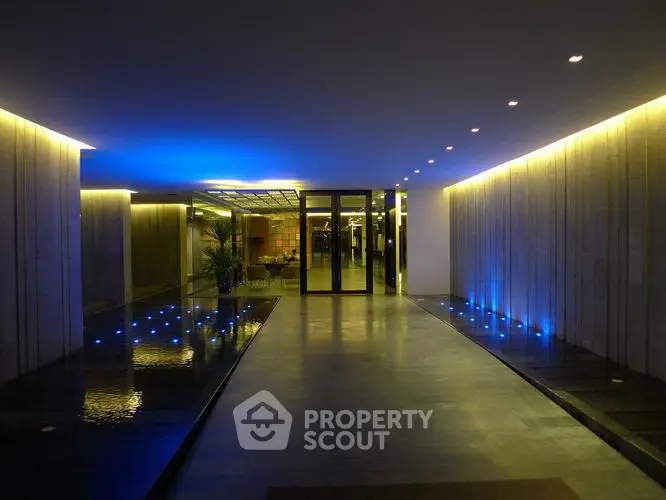 Luxurious modern building entrance with ambient lighting and sleek design.