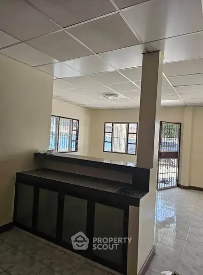 Spacious open-plan living area with large windows and modern ceiling design.