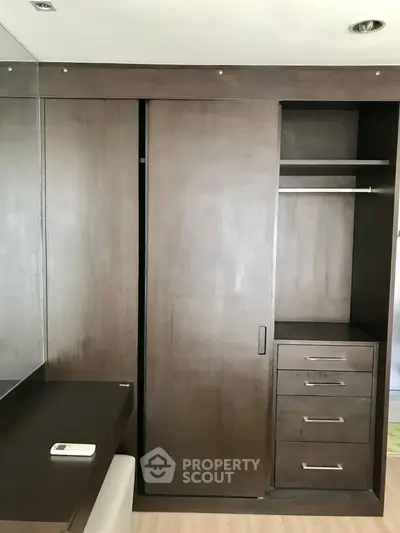 Modern wooden wardrobe with sliding doors and built-in drawers in a stylish bedroom.