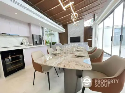 Luxurious modern dining area with elegant marble table and stylish chairs in open-plan living space.