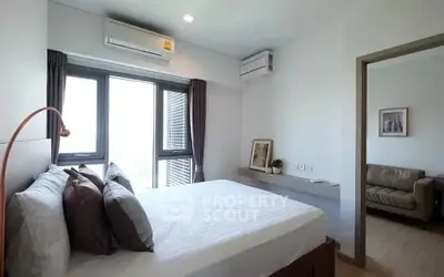 Modern bedroom with large window and air conditioning, adjacent to cozy living room.