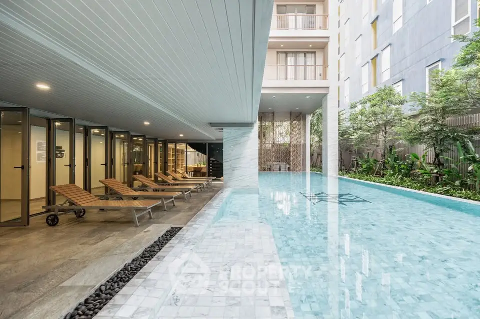 Luxurious apartment complex with a stunning pool and modern design, perfect for relaxation and leisure.