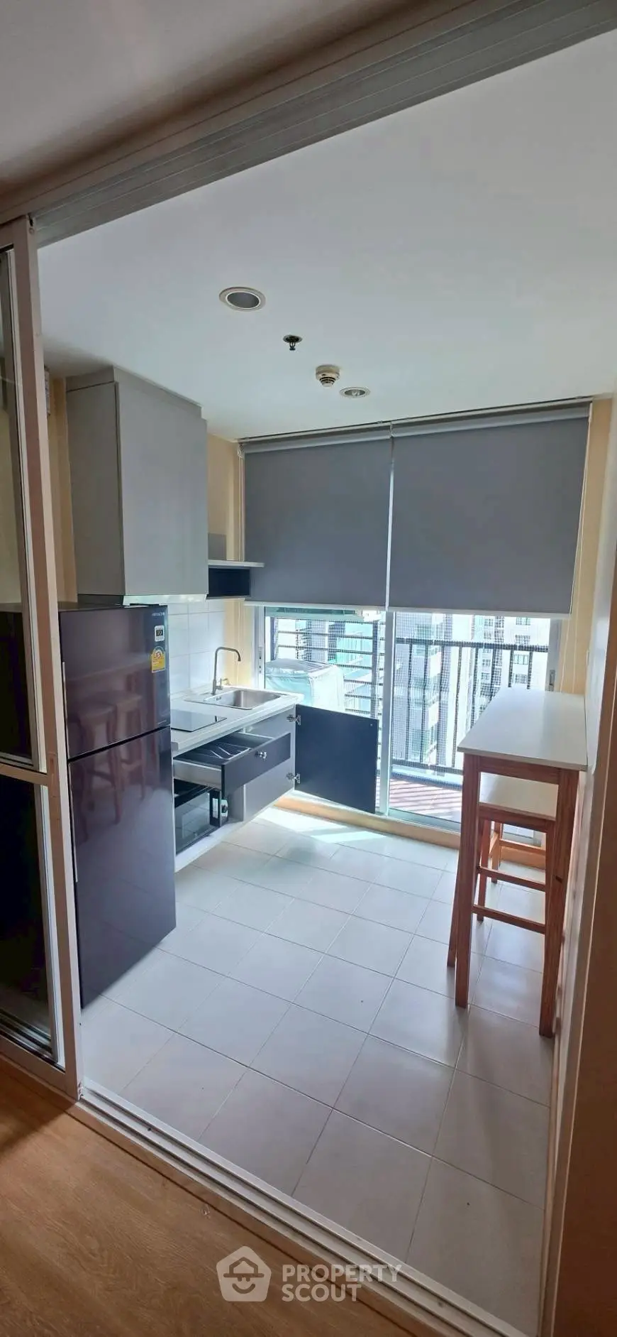 Modern kitchen with sleek cabinetry and large windows offering city views