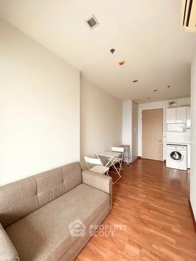 Modern living room with cozy sofa and compact dining area in a stylish apartment.