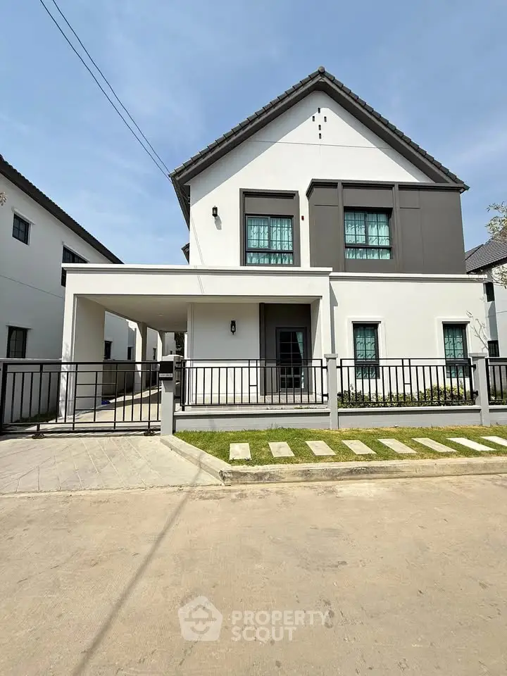 Modern two-story house with sleek design and spacious driveway in a serene neighborhood.
