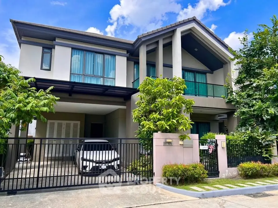 Stunning modern two-story house with lush greenery and spacious driveway in a serene neighborhood.