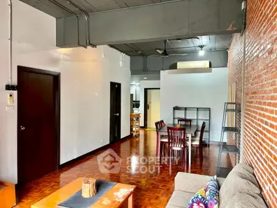 Spacious industrial-style living room with exposed brick and modern furnishings.