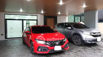 Modern home with spacious covered parking area featuring two cars.