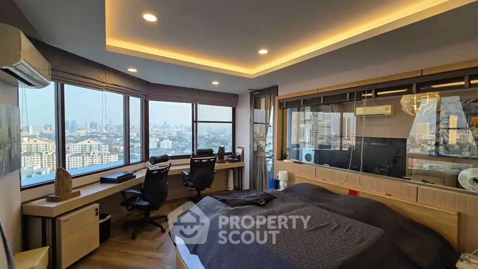 Luxurious corner bedroom with panoramic city views and modern furnishings.