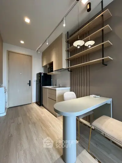 Modern kitchen with sleek design, integrated appliances, and stylish dining area in a contemporary apartment.
