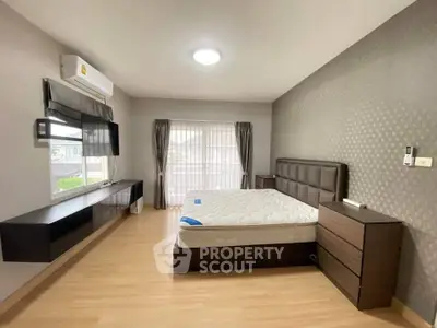 Spacious bedroom with modern decor and large window for natural light