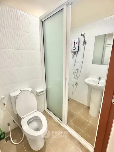 Modern bathroom with shower and toilet in a sleek, compact design.