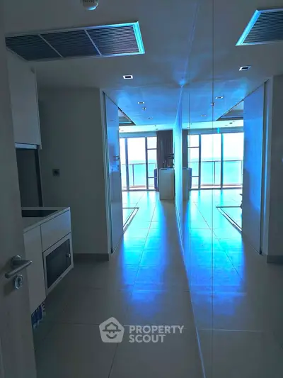 Modern apartment hallway with sleek design and large windows offering natural light.