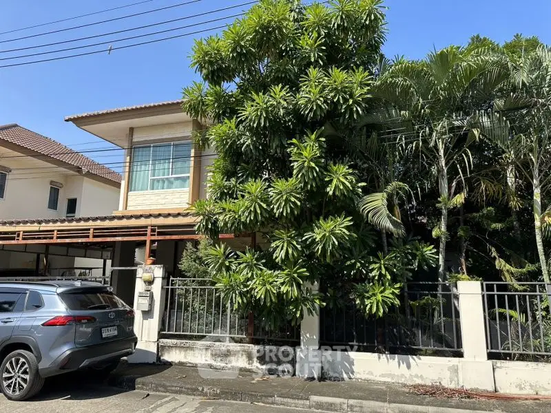 Charming suburban house with lush greenery and modern SUV parked in driveway.