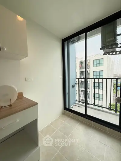 Modern apartment balcony with sliding glass doors and city view
