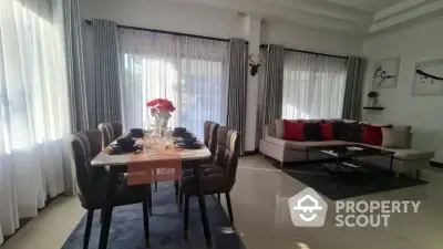 Elegant living room with dining area, modern furniture, and large windows for natural light.