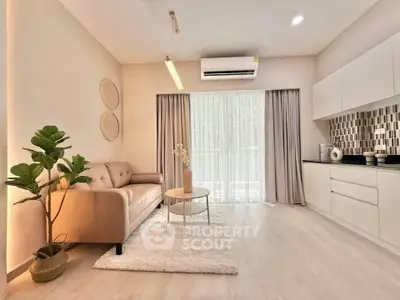 Modern living room with stylish decor and open kitchen layout, featuring a cozy sofa and elegant lighting.