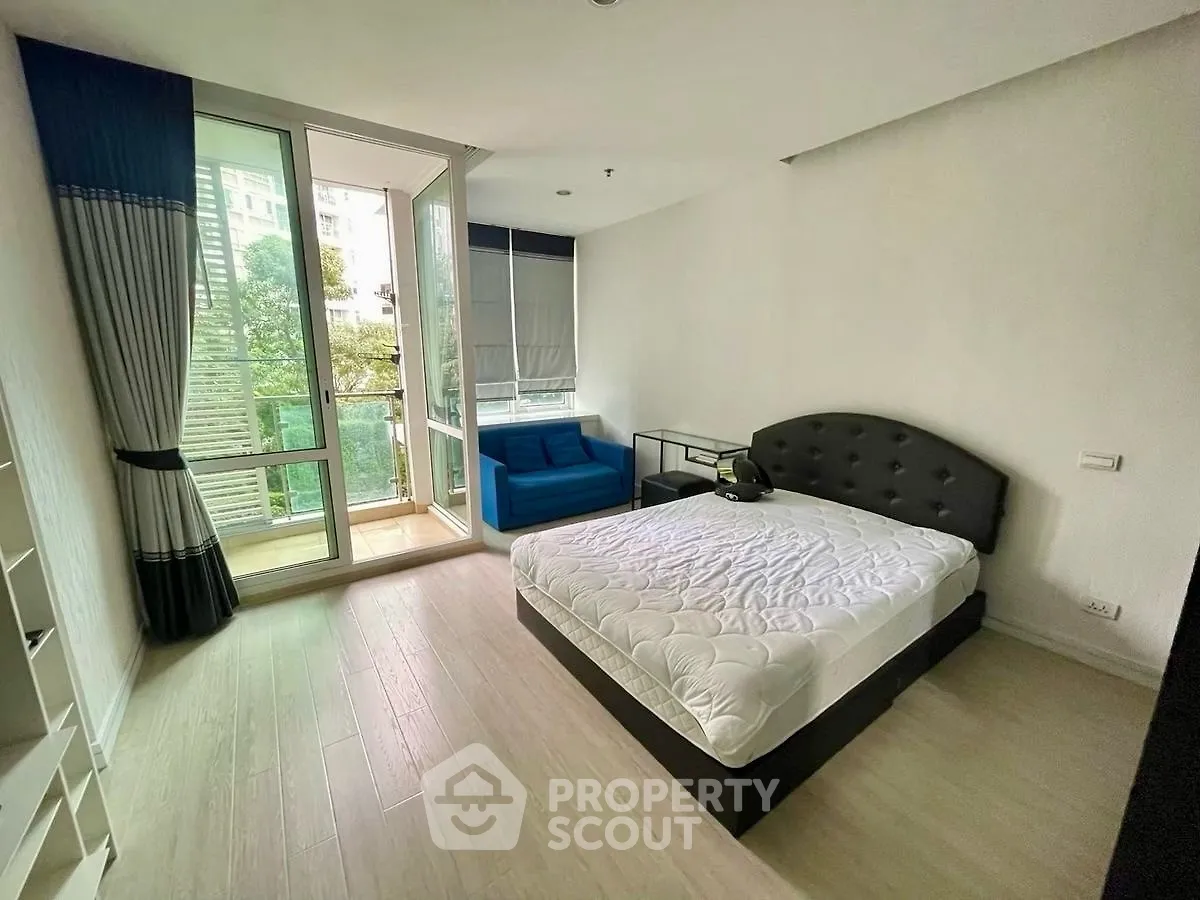 Spacious bedroom with balcony access and modern furnishings