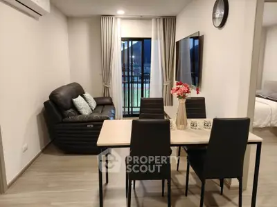 Modern living room with dining area and balcony view in a stylish apartment.