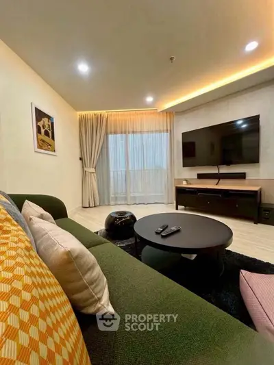 Modern living room with stylish decor, large TV, and cozy seating area, perfect for relaxation.