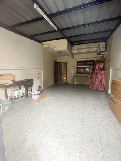 Spacious storage area with tiled flooring and ample lighting, perfect for versatile use.