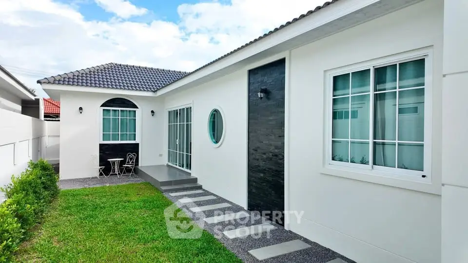 Charming single-story home with modern exterior and lush green lawn