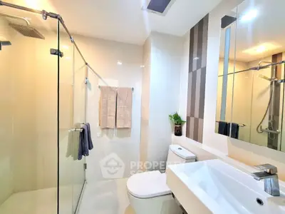 Modern bathroom with glass shower and sleek fixtures in a contemporary apartment.