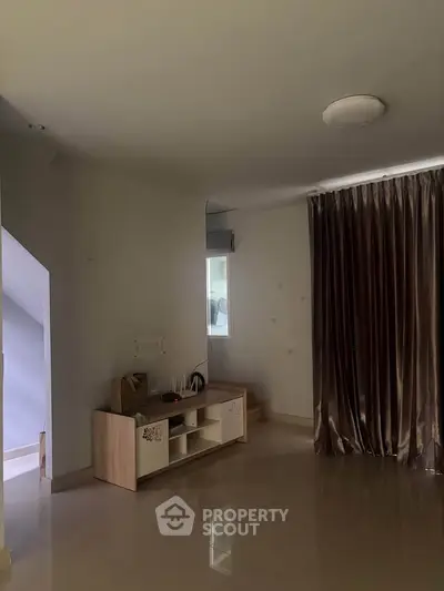 Spacious living area with modern decor and elegant curtains