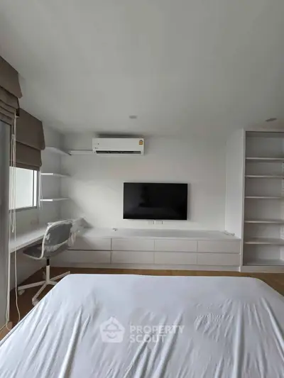 Modern bedroom with built-in shelves, wall-mounted TV, and air conditioning unit.
