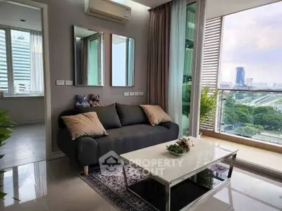 Modern living room with city view, stylish sofa, and elegant decor in high-rise apartment.