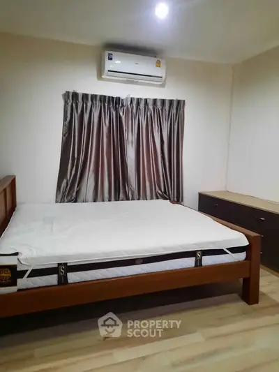 Cozy bedroom with air conditioning and elegant curtains, perfect for restful nights.
