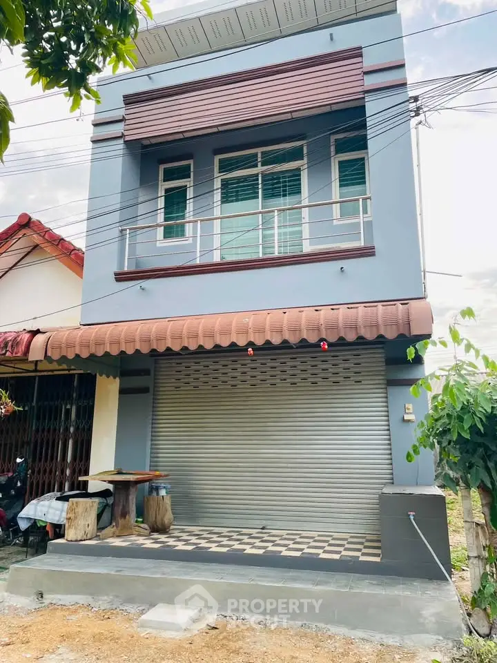 Modern two-story building with a sleek facade and secure roller shutter entrance.
