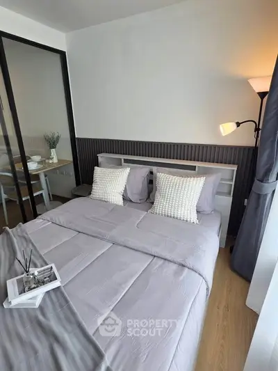 Modern bedroom with cozy bedding and stylish decor in a contemporary apartment.