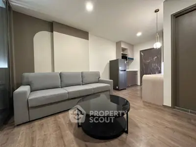 Modern living room with sleek furniture and open kitchen layout, perfect for contemporary living.