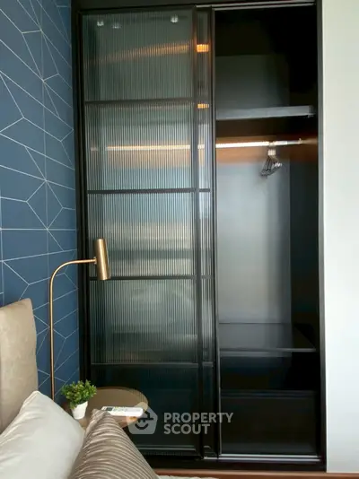 Modern bedroom with sleek black wardrobe and geometric accent wall