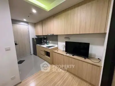 Modern kitchen with sleek wooden cabinets and integrated appliances in a compact layout.