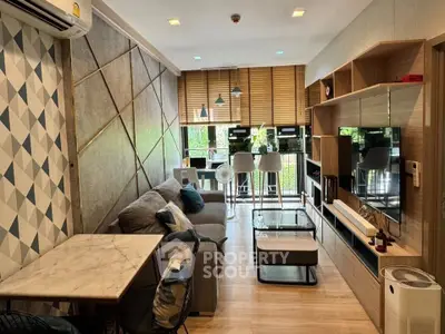 Modern living room with stylish decor and open layout, featuring a cozy sofa and entertainment unit.