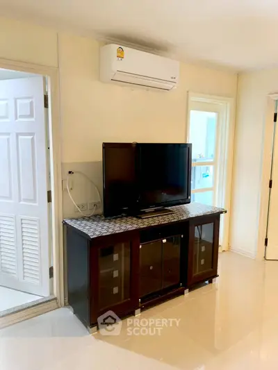 Modern living room with sleek TV stand and air conditioning unit, perfect for comfortable living.