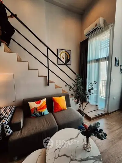 Modern living room with stylish decor and mezzanine staircase, featuring vibrant cushions and natural light.