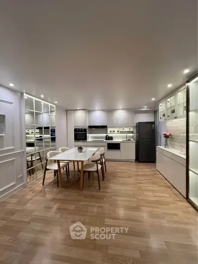 Modern kitchen with sleek design, featuring open layout, dining area, and contemporary appliances.