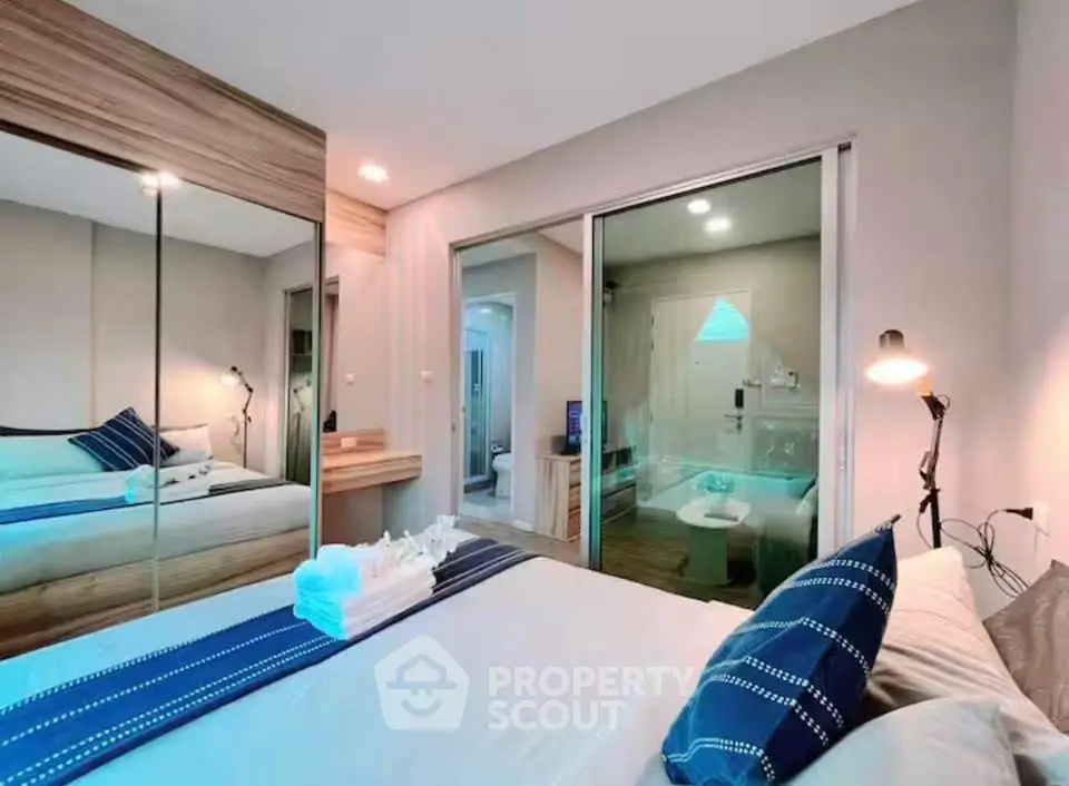 Modern bedroom with mirrored wardrobe and cozy decor in a stylish apartment.