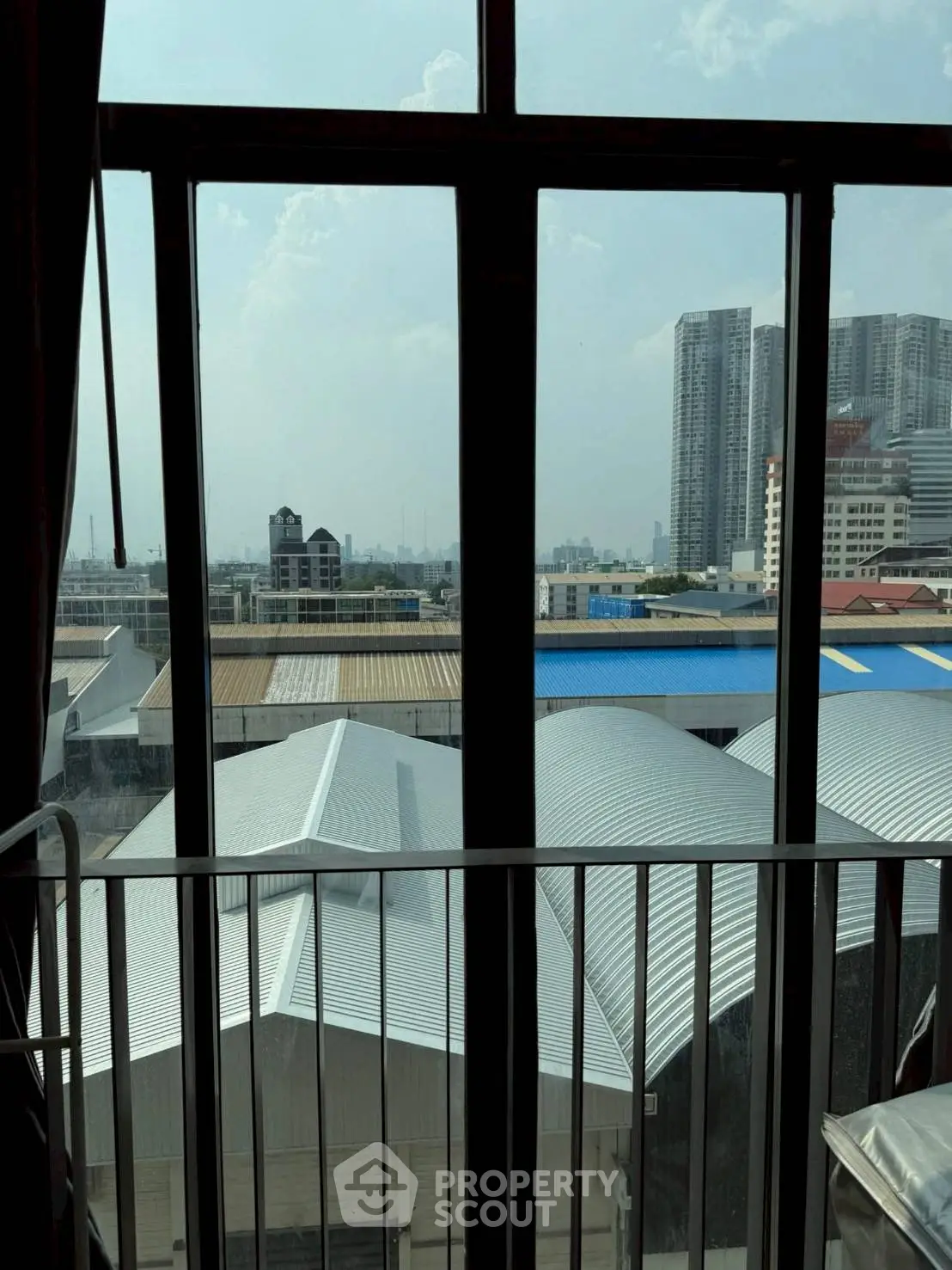 Stunning urban view from high-rise window showcasing city skyline and modern architecture.