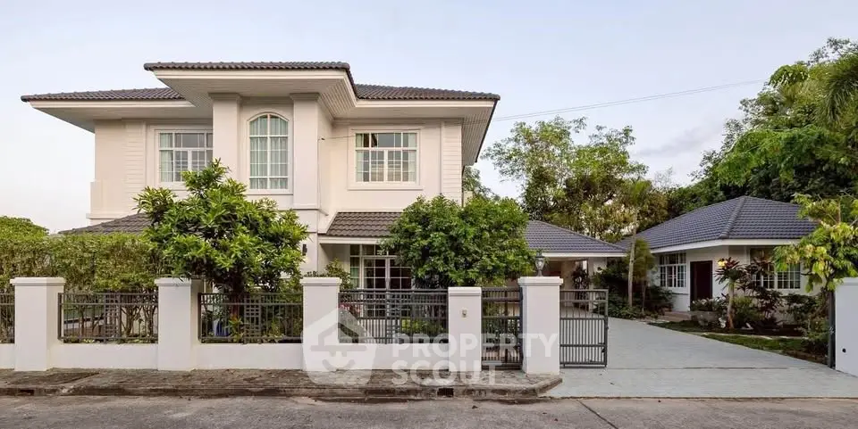 Elegant two-story house with lush garden and spacious driveway in serene neighborhood.