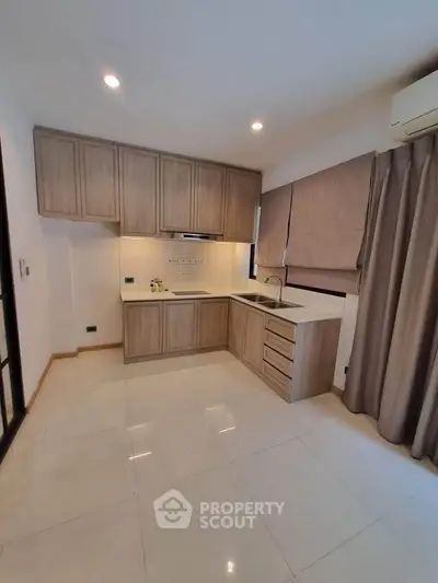 Modern kitchen with sleek cabinetry and neutral tones, featuring an open layout and ample natural light.