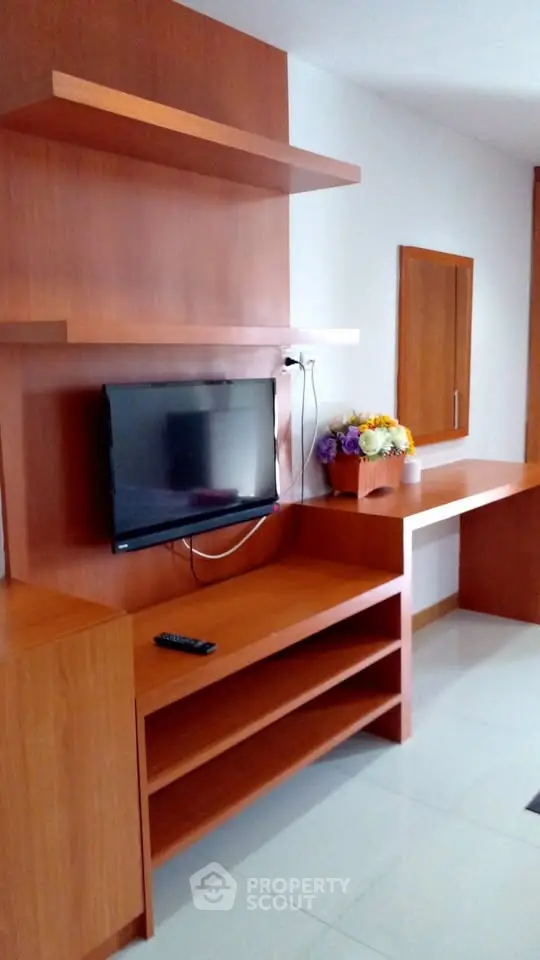 Modern living room with wooden shelves and mounted TV, perfect for cozy entertainment.