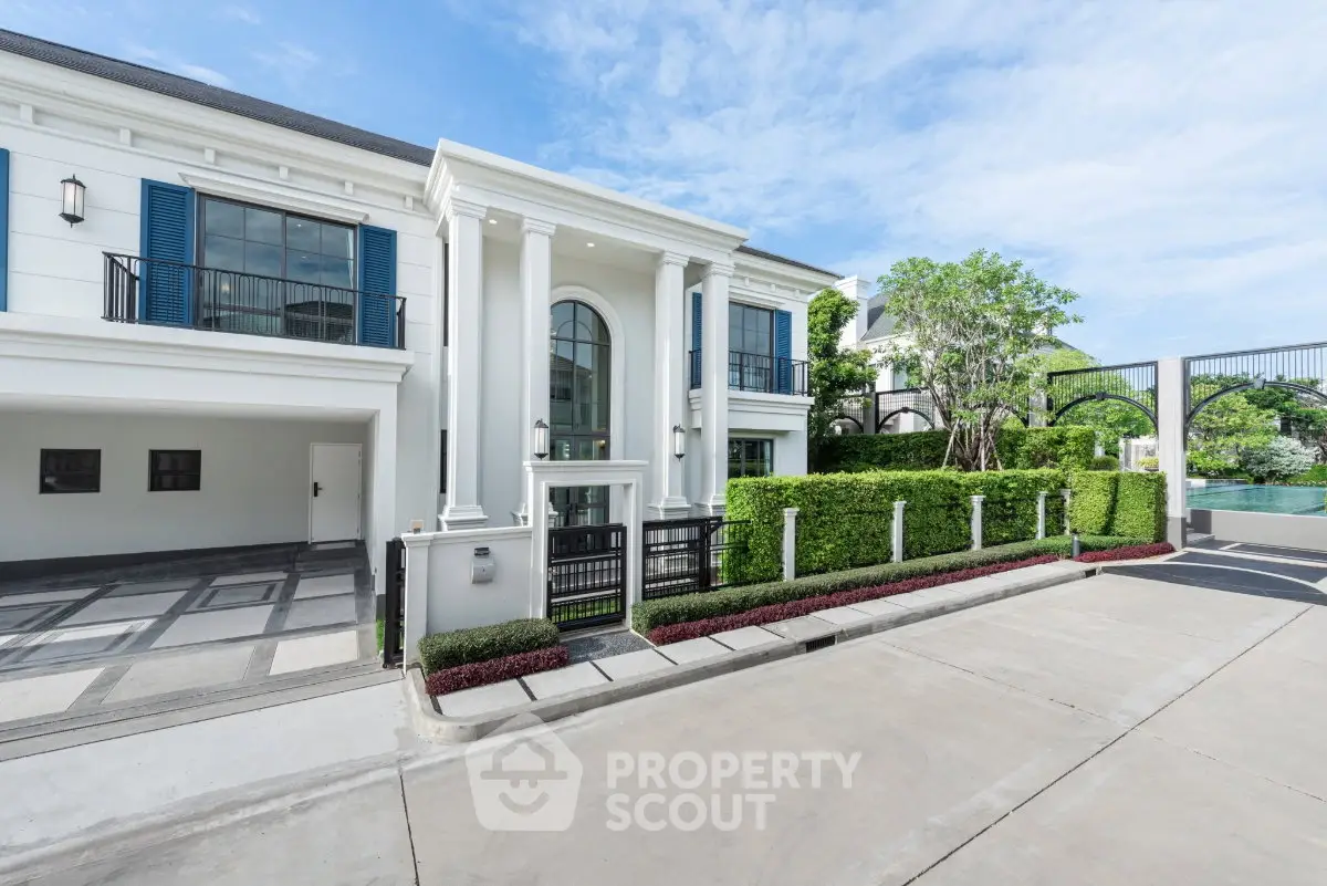 Luxurious modern mansion with grand entrance and manicured landscaping in upscale neighborhood.