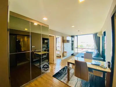 Modern living room with dining area and large windows offering natural light.