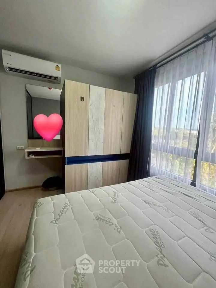 Modern bedroom with large window and air conditioning, featuring stylish wardrobe and comfortable mattress.