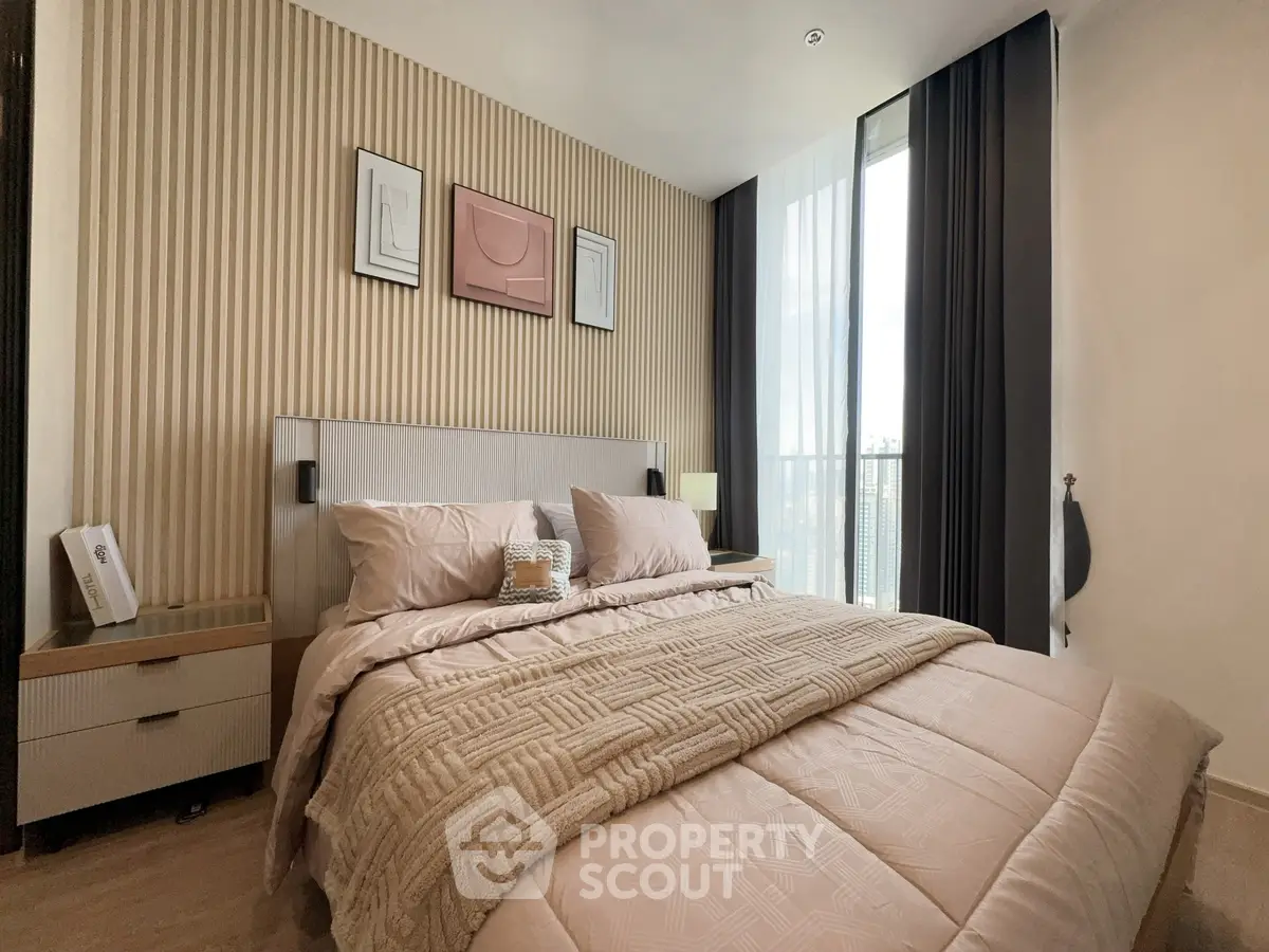 Luxurious bedroom with modern decor and large window offering natural light